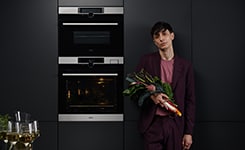 Man holding flowers in front of oven